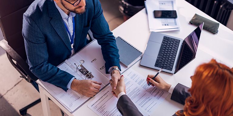 Intermediário e cliente de crédito a analisar as taxas TAN, TAE e TAEG