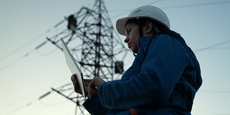 Técnica da área da eletricidade com capacete