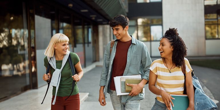 Grupo de jovens sorridentes conversam sobre devolução de propinas