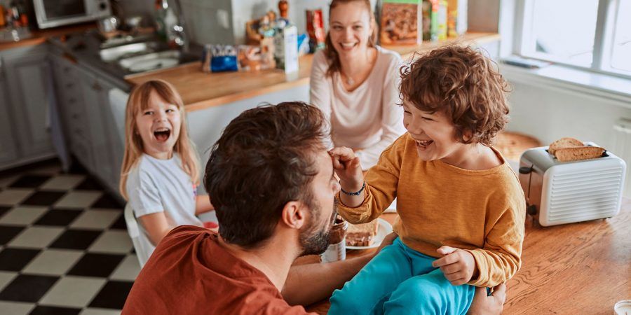 pais e filhos de agregado com imi familiar reunidos na cozinha