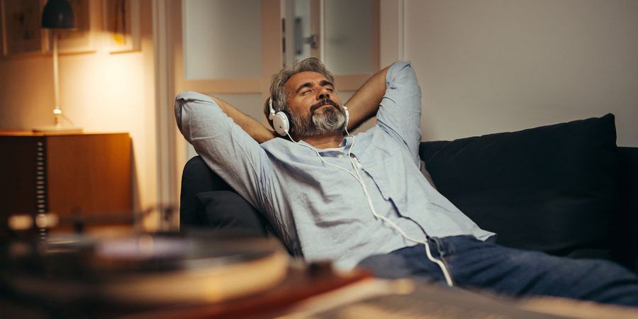Homem de headphones nos ouvidos, aproveita o tempo livre porque tem estabilidade financeira graças aos rendimentos passivos