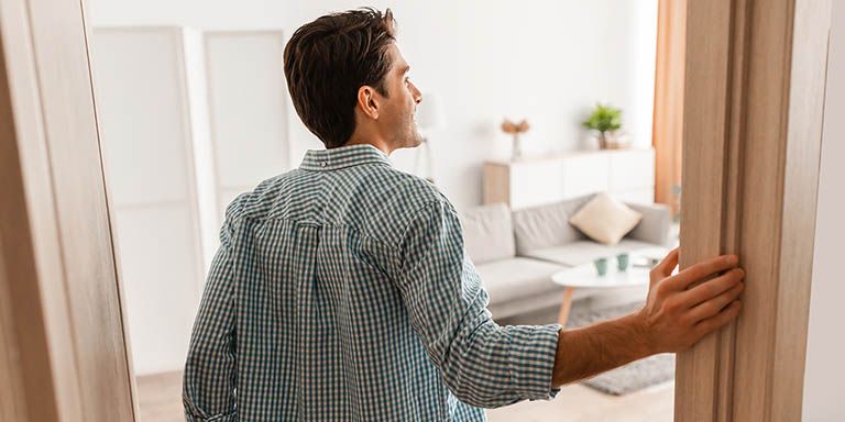 Homem de camisa de xadrez a entrar na sala está a avaliar que seguro deve fazer para o recheio da casa