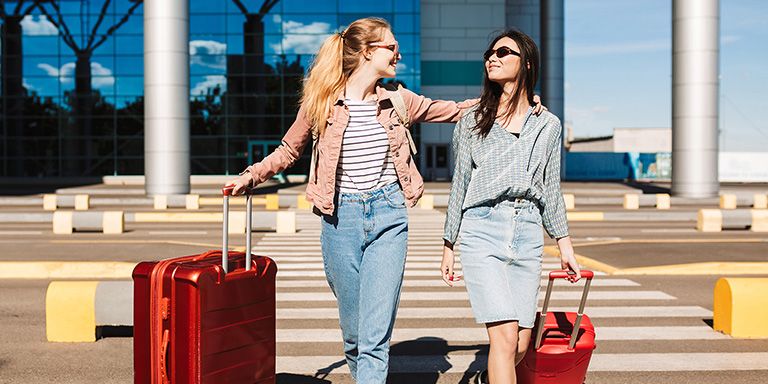 Duas amigas com malas vermelhas. Agora que receberam o subsídio de férias já podem viajar.