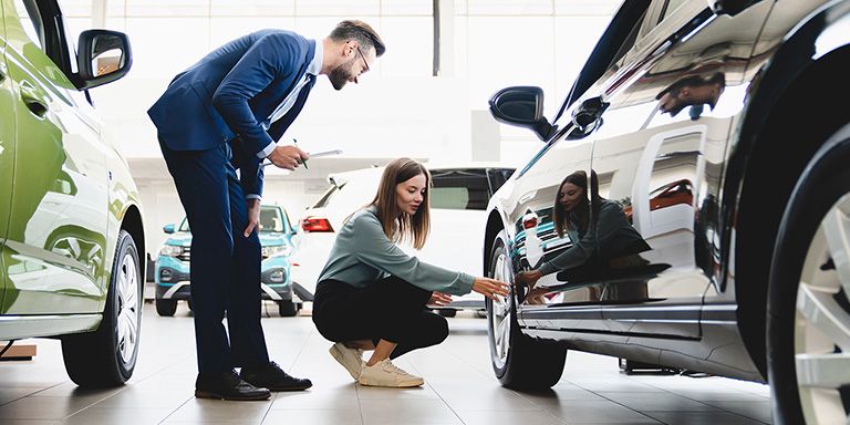 Casal analisa carro novo. Mas afinal quanto custa ter um carro?