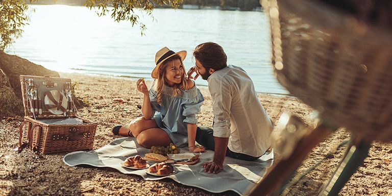 Casal fezli a fazer um picnic, uma forma de poupar em atividades de lazer