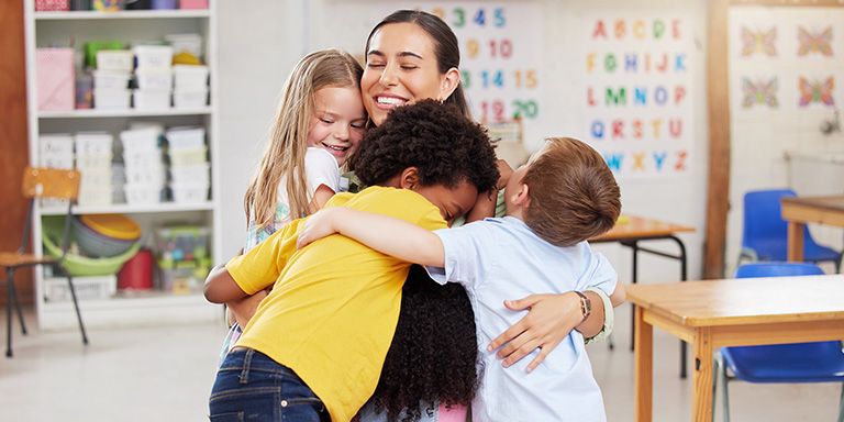 Educadora abraça crianças