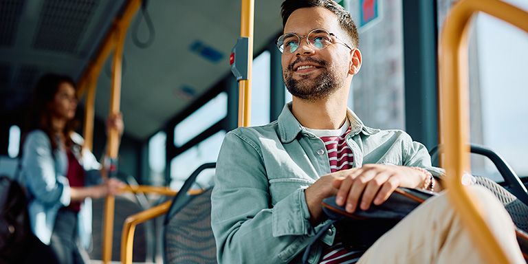 Homem de barba e óculos no autocarro: decidiu começar a poupar nos transportes