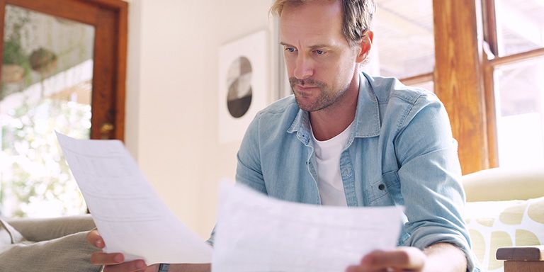 Senhor a analisar contas para reduzir gastos
