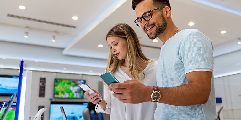 Casal a comprar telemóveis recondicionados